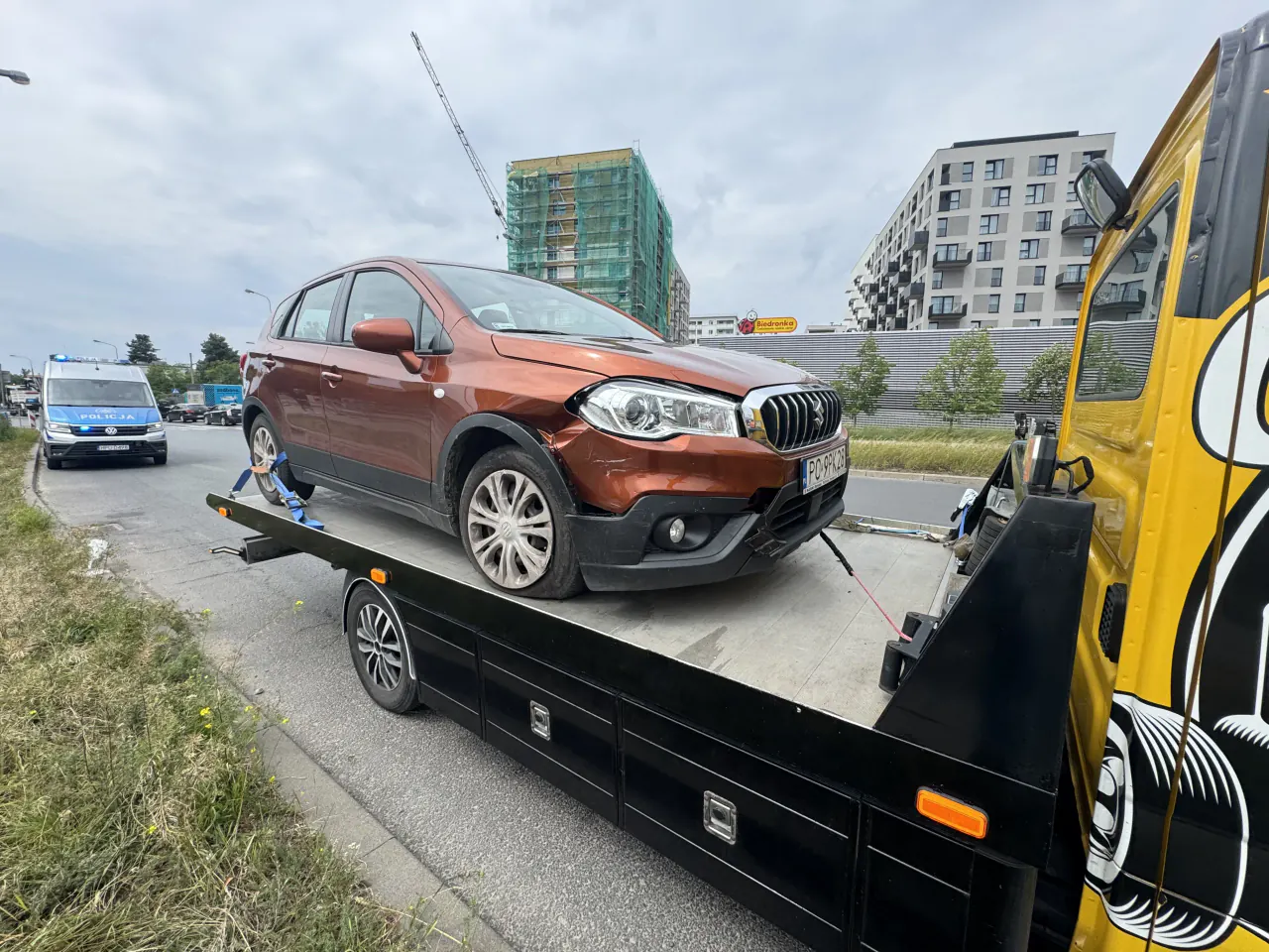 Uszkodzony brązowy samochód załadowany na autolawetę