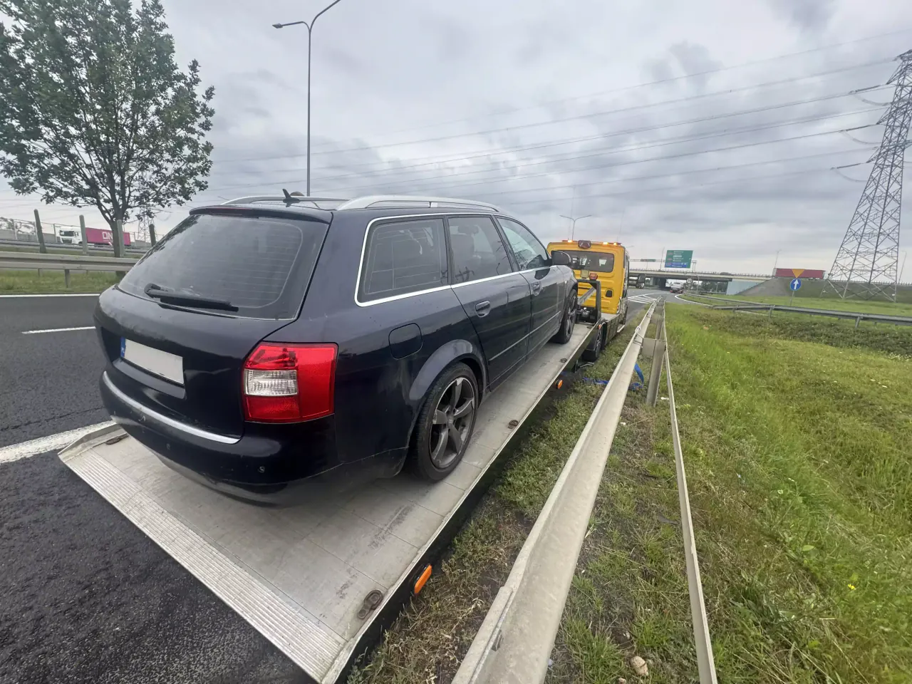 Samochód kombi na platformie autolawety przy drodze szybkiego ruchu