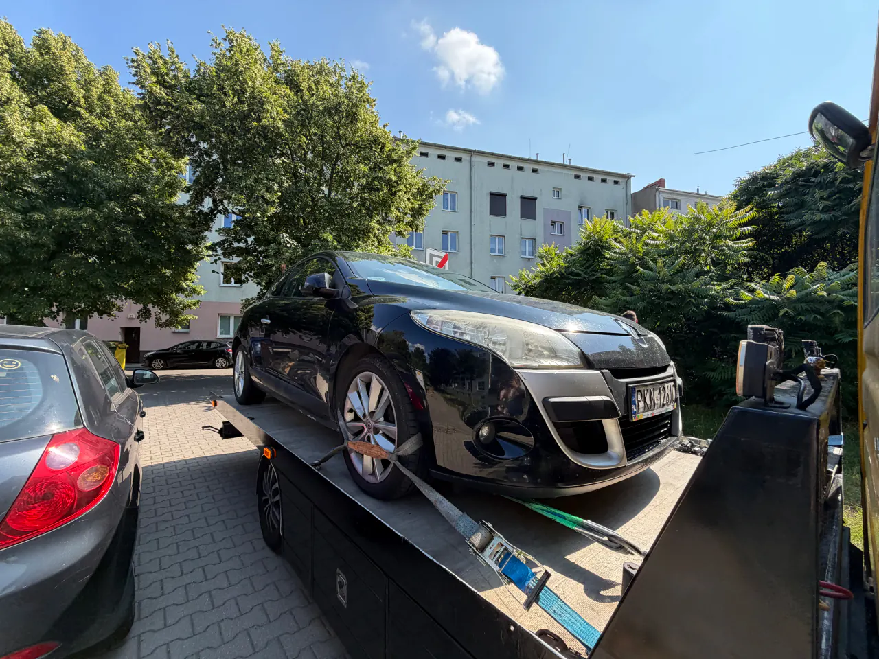 Czarny samochód osobowy ustawiony na platformie autolawety